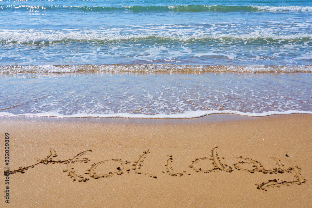 Holiday inscription on a tropical sandy beach with waves and foam on a background. Holiday inscription on a tropical sandy beach with waves and foam on a background.