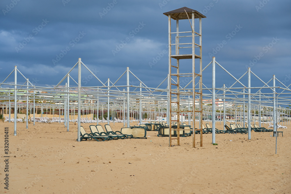Empty sundy beach outside of the holiday season with cloudy sky on a background. Empty sundy beach outside of the holiday season with cloudy sky on a background.