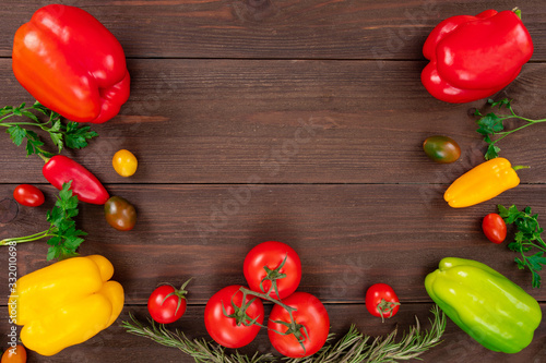 Top view of various fresh vegetables and herbs on wooden background with copy space