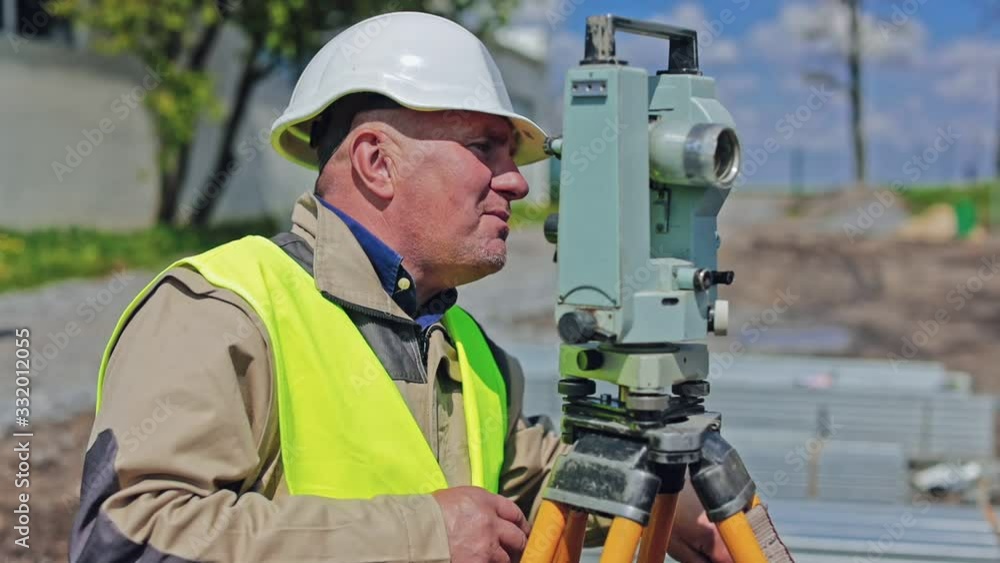 Survey engineer at construction site. Construction engineers supervising progress of construction project Survey engineer at construction site. Construction engineers supervising progress of construction project