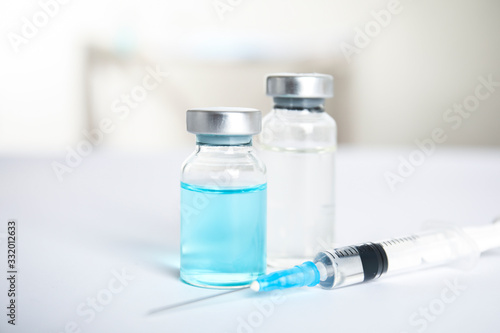 Vials and syringe on light background. Vaccination and immunization