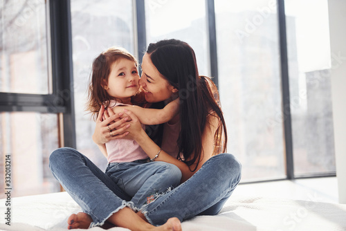 Young mother with her daughter embracing each other on bed © standret