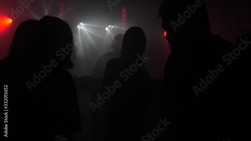 A crowd of people dancing at a music festival. A party in the big hall photo