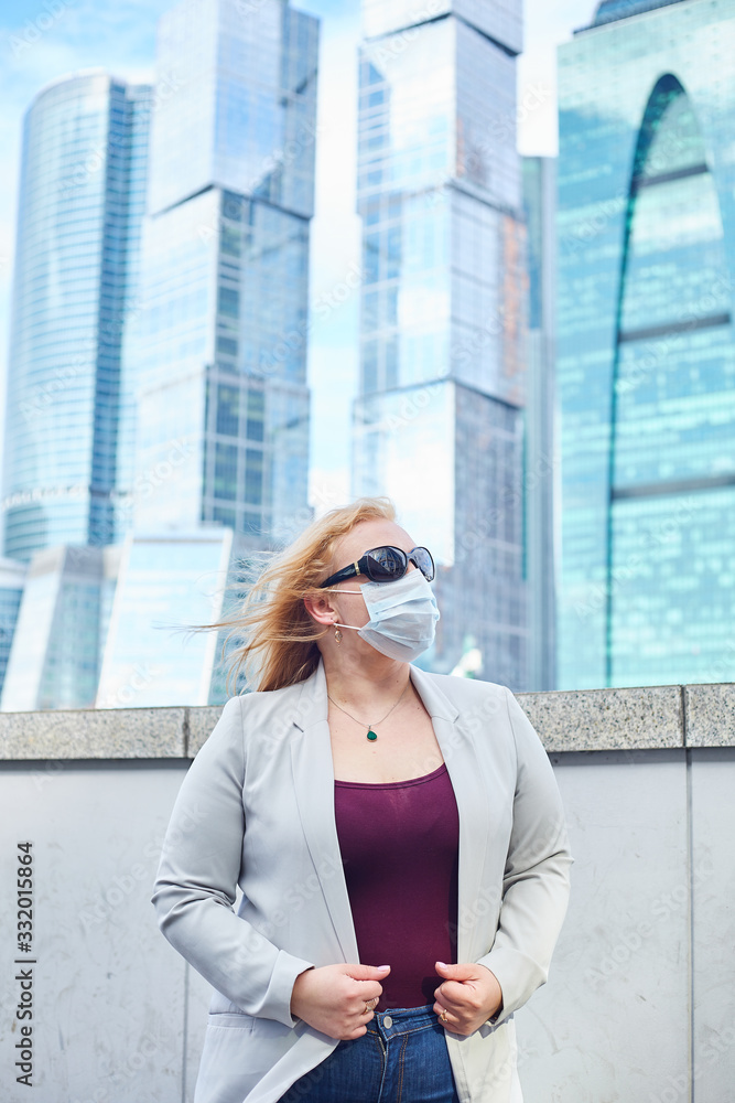 blonde girl stay at street near business center in a medical mask blonde girl stay at street near business center in a medical mask