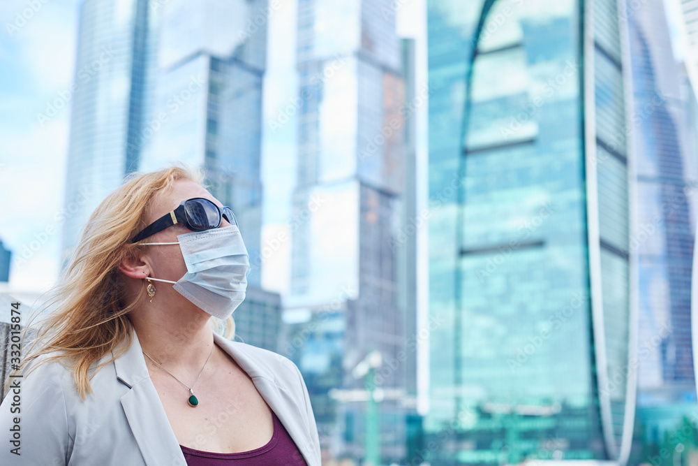 blonde girl stay at street near business center in a medical mask blonde girl stay at street near business center in a medical mask