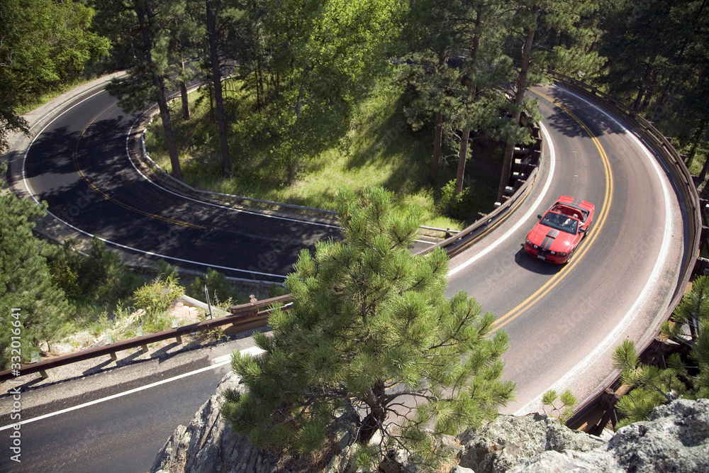 Red convertible driving on Iron Mountain Road, Black Hills, near Mount