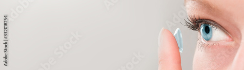 Woman inserting a contact lens in eye.