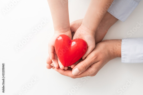 The adult and the child holding red heart.