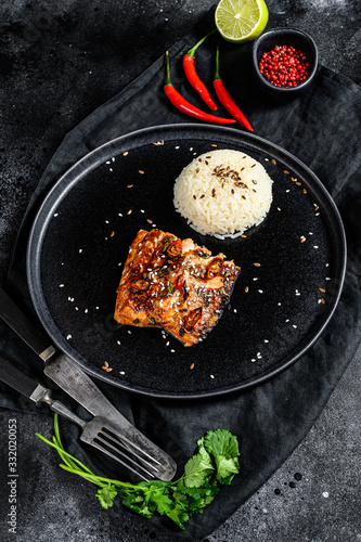 Japanese Teriyaki grilled salmon fillet glazed in delicious sauce with a side dish of rice. Black background. Top view