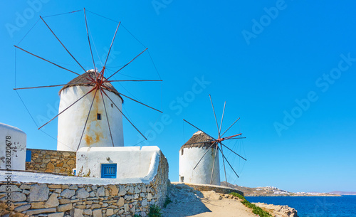 Old white windmillls by the sea in Mykonos