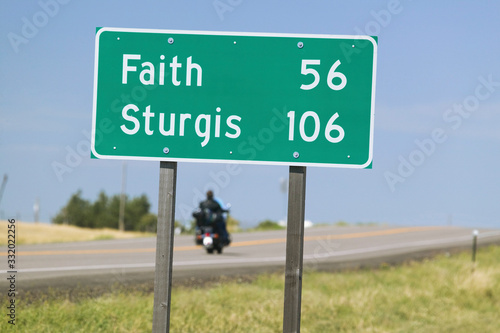State Highway 34 with highway sign for Sturgis South Dakota and motorcycle driver heading for the 67th Annual Sturgis Motorcycle Rally, Sturgis, South Dakota, August 6-12, 2007