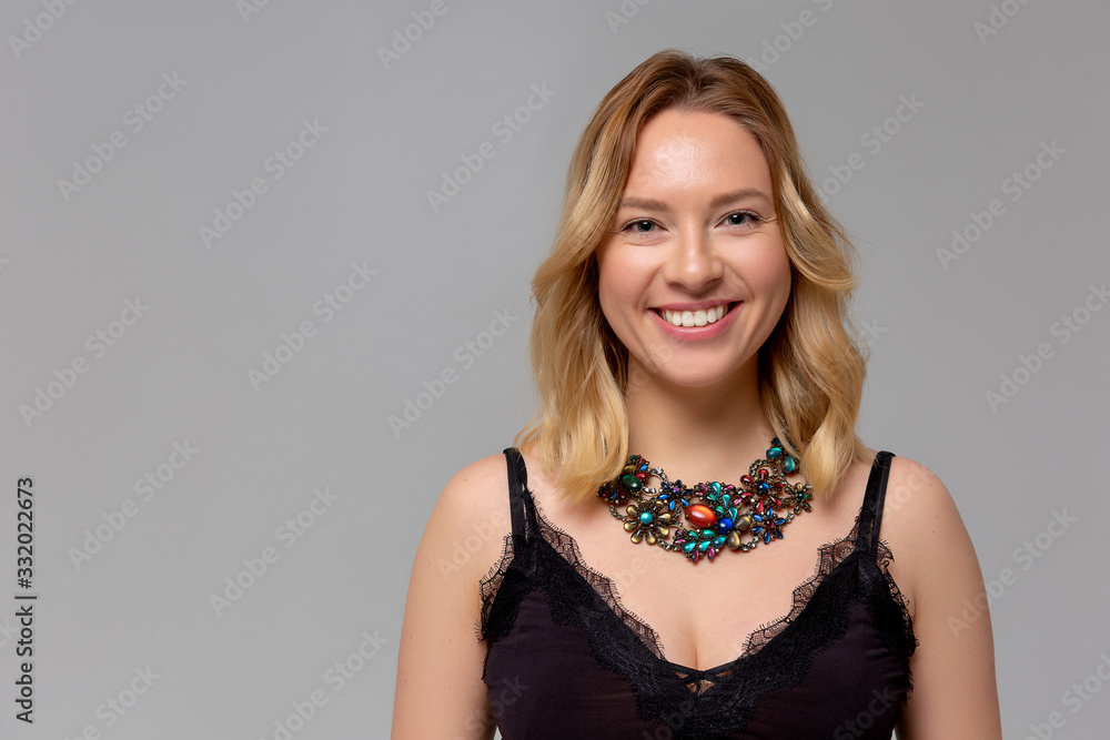 Portrait of young pretty cheerful girl with jewerly smiling looking at camera over monochromatic background. Portrait of young pretty cheerful girl with jewerly smiling looking at camera over monochromatic background.