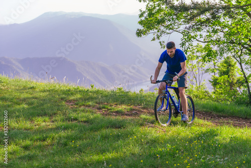 Adventurous mountain biker riding his bike fast through the woods ( forest ) while enjoying the green nature.