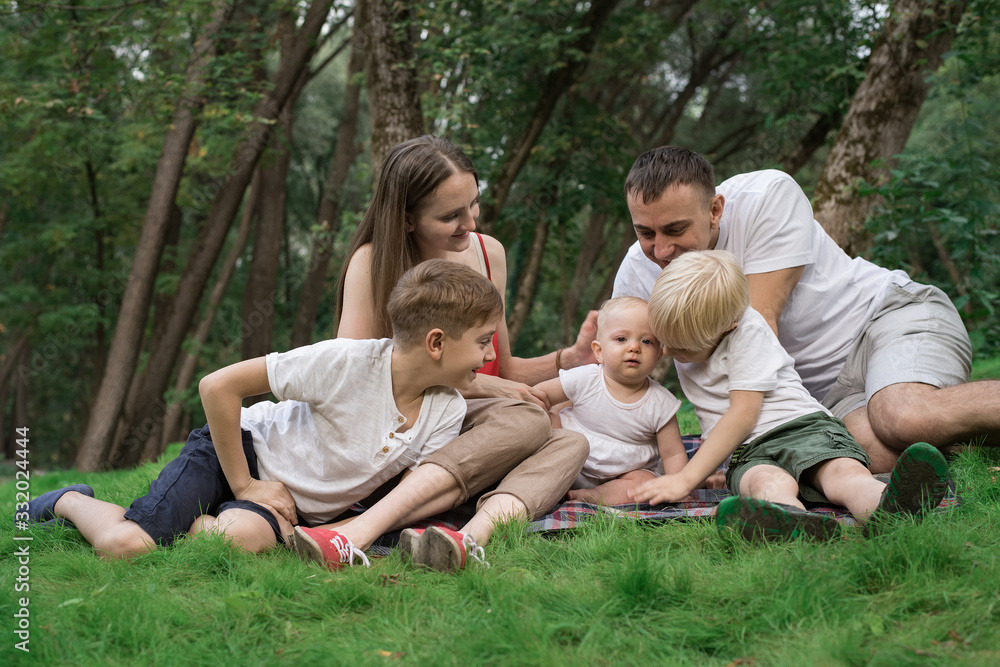 Young family with three children outdoors. Big happy family resting in nature Young family with three children outdoors. Big happy family resting in nature