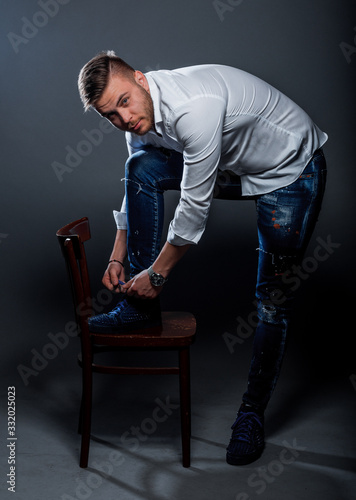 Stylish fashion man tying shoelaces