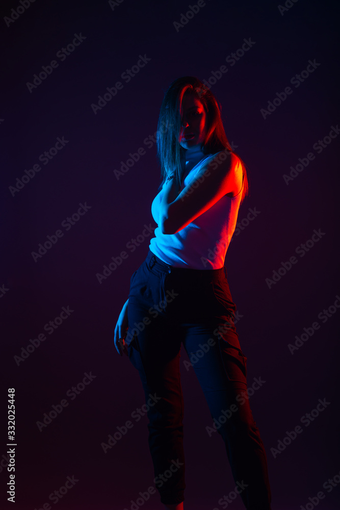 Blue and red light portrait of a female model on a black background with high contrast