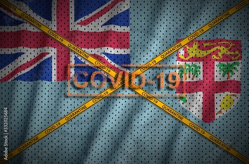 Fiji flag and Covid-19 stamp with orange quarantine border tape cross. Coronavirus or 2019-nCov virus concept photo