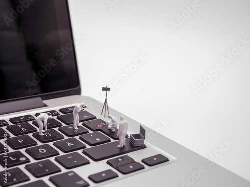 Miniatur scientists examining laptop keyboard photo