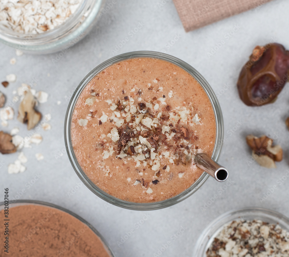 Vegan drink smoothies made from dried fruits, nuts, chocolate in a glass on a light background top view