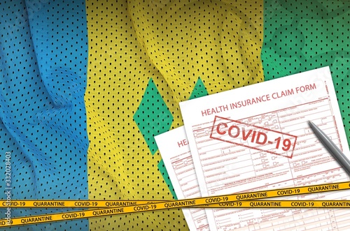 Saint Vincent and the Grenadines flag and Health insurance claim form with covid-19 stamp. Coronavirus or 2019-nCov virus concept photo