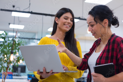 Two Creative office workers collaborate together to discuss main ideas for creating businness investment plan, analyze presentation on laptop computer photo