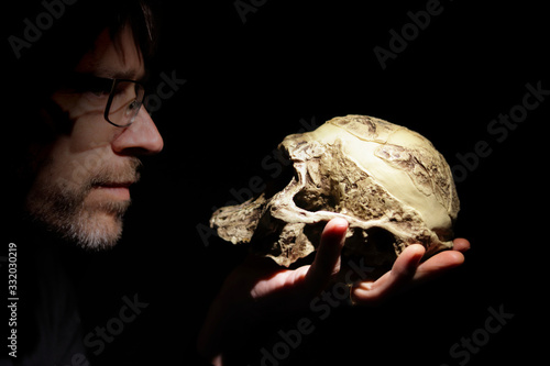 Teacher with an Australopithecus africanus skull model on his hand. photo