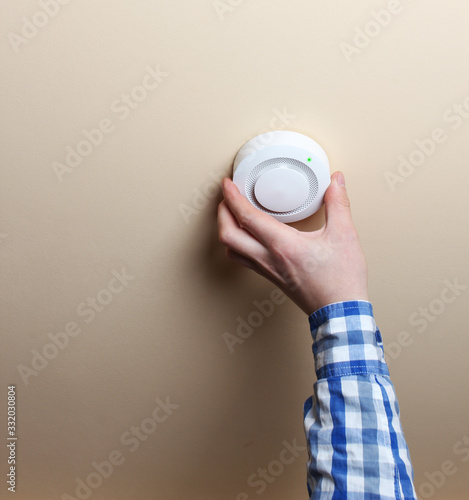 fire alarm sensor hand on an orange light background