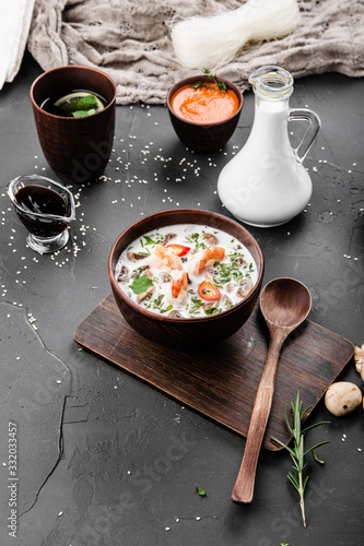 Chinese dishes in a clay plate on a black concrete background with ingredients for delivery