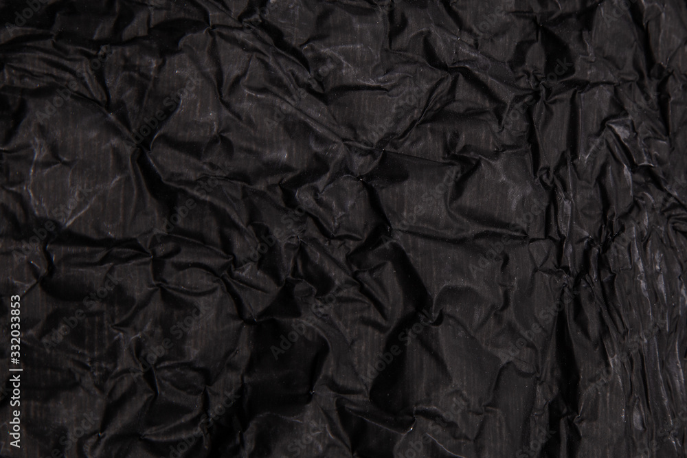 Fototapeta premium Black background. A crumpled texture. Close-up.