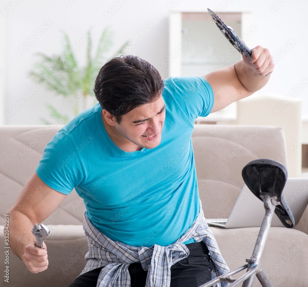 Young man repairing bicycle at home Young man repairing bicycle at home