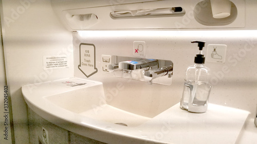 Bathroom sink in a commercial airplane with personal cleaning products