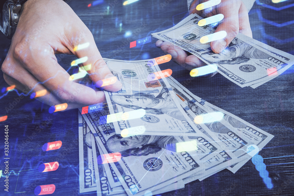 Multi exposure of technology drawing hologram and us dollars bills and man hands. Data concept Multi exposure of technology drawing hologram and us dollars bills and man hands. Data concept