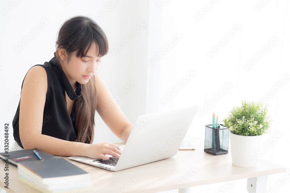 Beautiful freelance asian woman smiling working and typing on laptop computer at desk office with professional, girl using notebook checking email or social network, business and lifestyle concept. Beautiful freelance asian woman smiling working and typing on laptop computer at desk office with professional, girl using notebook checking email or social network, business and lifestyle concept.