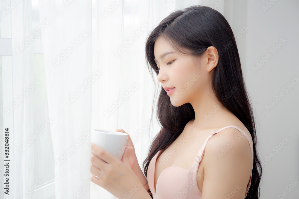 Beautiful young asian sexy woman in underwear drinking coffee near windows in the morning, girl with seductive figure fit drinking beverage for relax and resting after wake up, lifestyle concept. Beautiful young asian sexy woman in underwear drinking coffee near windows in the morning, girl with seductive figure fit drinking beverage for relax and resting after wake up, lifestyle concept.