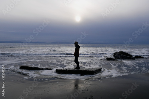 Man stood alone on rock at the beach