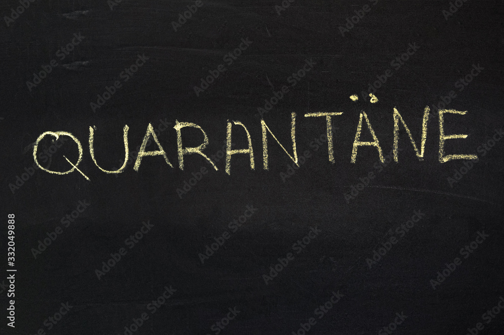 Fototapeta premium The word is in German quarantine. The text on the chalk Board. Yellow chalk