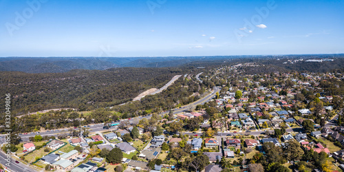 Aerial drone photo of Kuring Gai Chase National Park  Berowra and the Pacific Highway and M1 Motorway  Mount Kuring Gai  distant right  and Sydney CBD to the horizon on a clear sunny day.