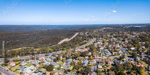 Photography Aerial drone photo of Kuring Gai Chase National Park, Berowra and the Pacific Highway and M1 Motorway, Mount Kuring Gai (distant right) and Sydney CBD to the horizon on a clear sunny day