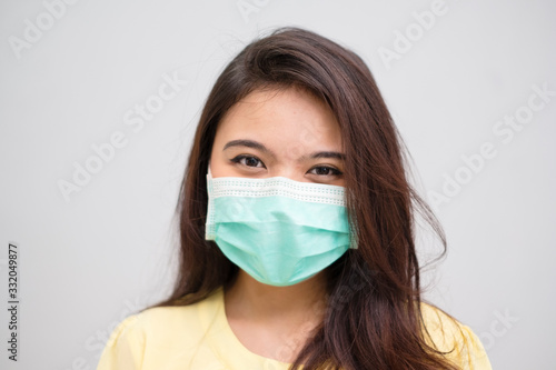 Portrait of a cheerful and healthy young woman asian wearing medical mask. Pandemic 2019 Coronavirus 2019-nCoV Concept.