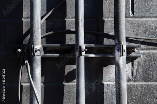 Close up of conduit on brick wall with strong shadows