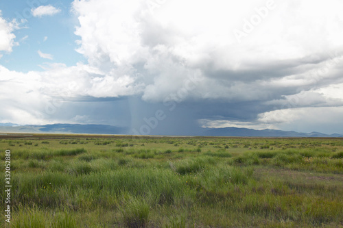 Storm clouds over grasslands and mountains at Red Rock Lake in Centennial Valley, near Lakeview, MT