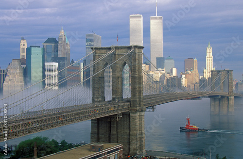 View of New York skyline, Brooklyn Bridge over the East River and tugboat in fog, NY