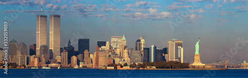 Panoramic sunset view of World Trade Towers, Statue of Liberty, Brooklyn Bridge, and Manhattan, NY skyline