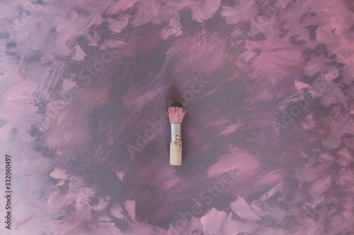 brush on top of unfinished work of an abstract textured painting or photography backdrop with pink and grey  toned acrylic paint photo