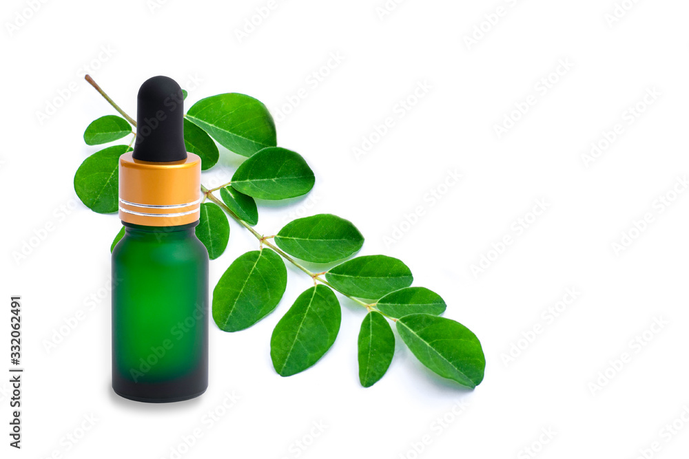 Moringa oil with green leaf isolated on white. Moringa oil with green leaf isolated on white.