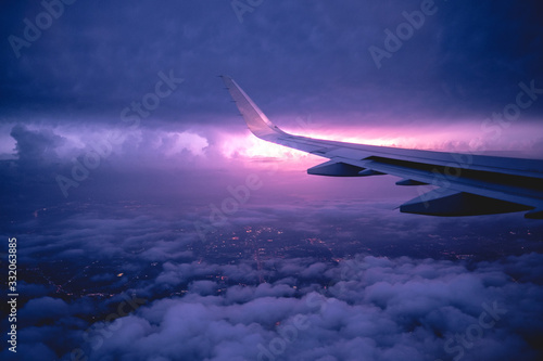 Flying on plane in a storm at night over Dallas with lightning in the horizont, USA