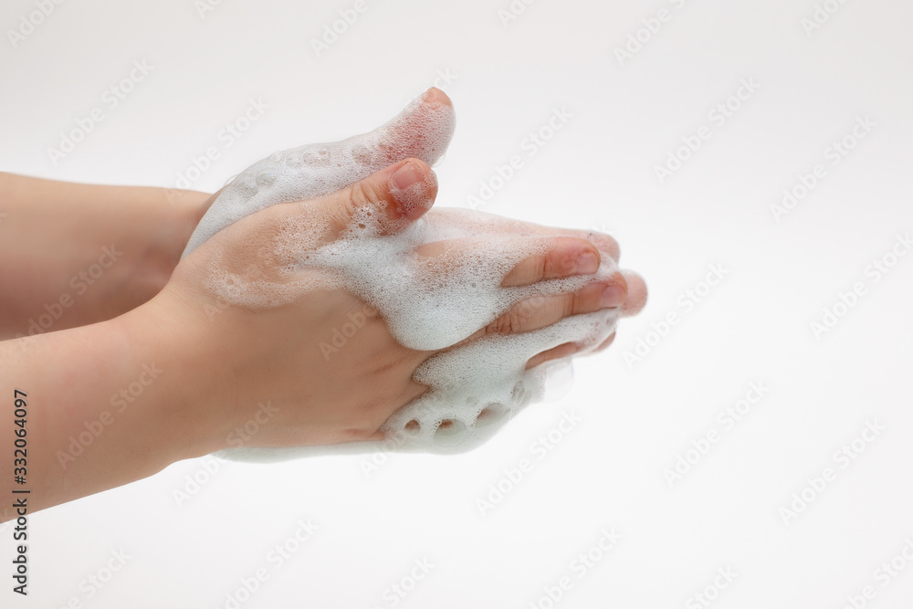 Hands of child on a white background in white foam from antibacterial soap Hands of child on a white background in white foam from antibacterial soap