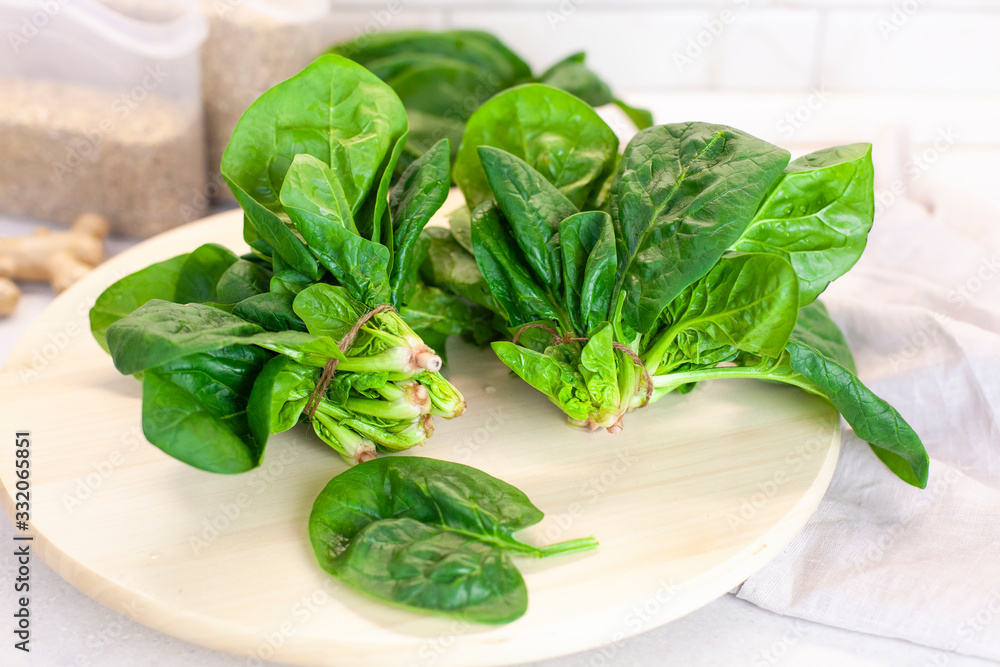 Close-up of spinach on the kitchen table on a light background Close-up of spinach on the kitchen table on a light background