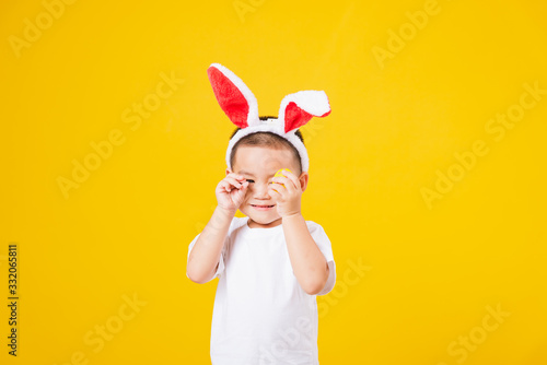 little children boy smile standing so happy bunny ears in Easter festival day holding easter eggs