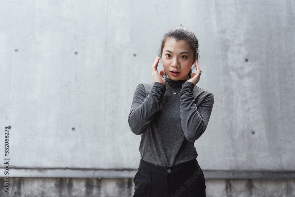 Asian young business women in front of gray walls Asian young business women in front of gray walls